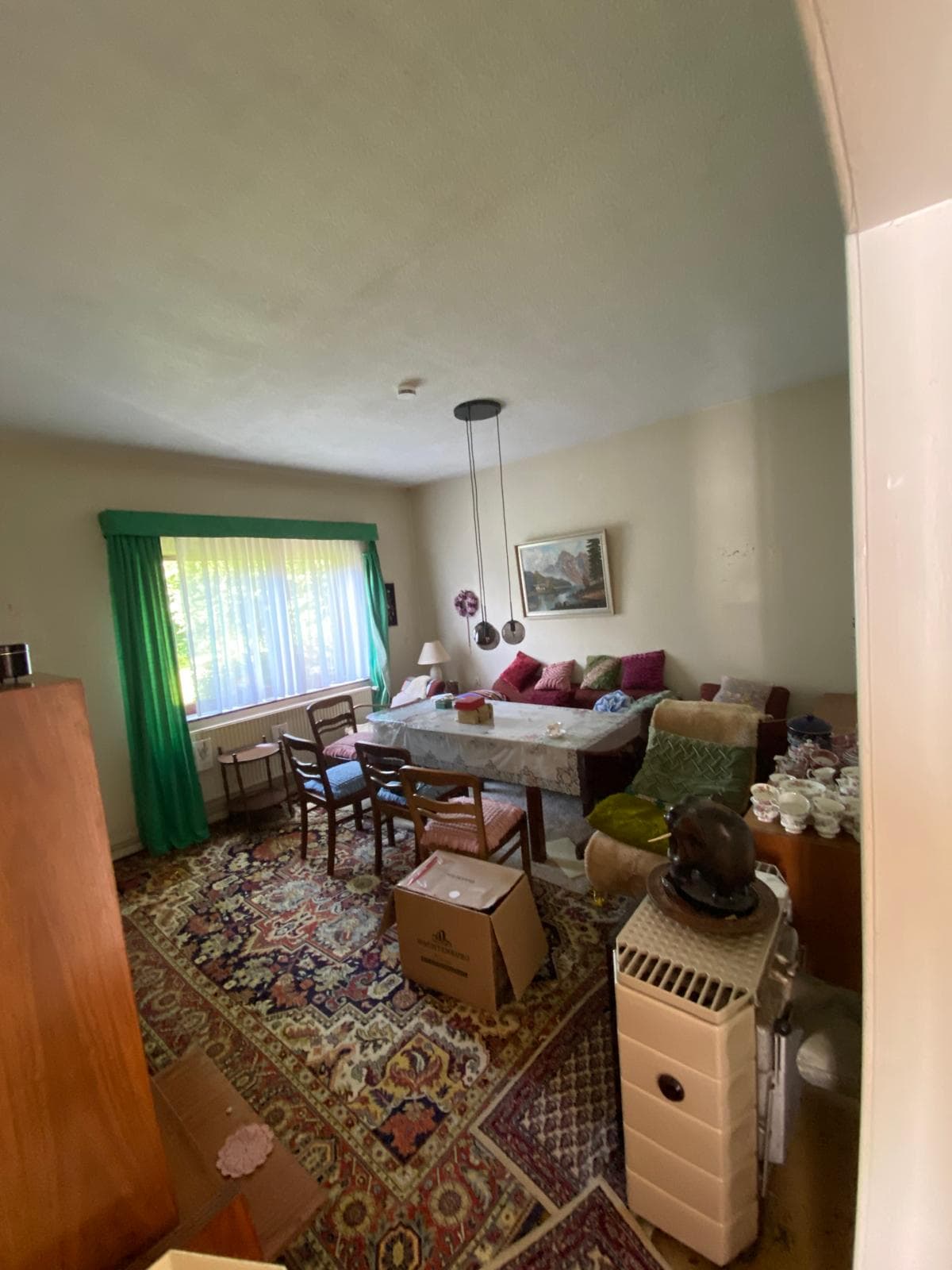 Wohnzimmer mit Esstisch, Sofa und Teppich