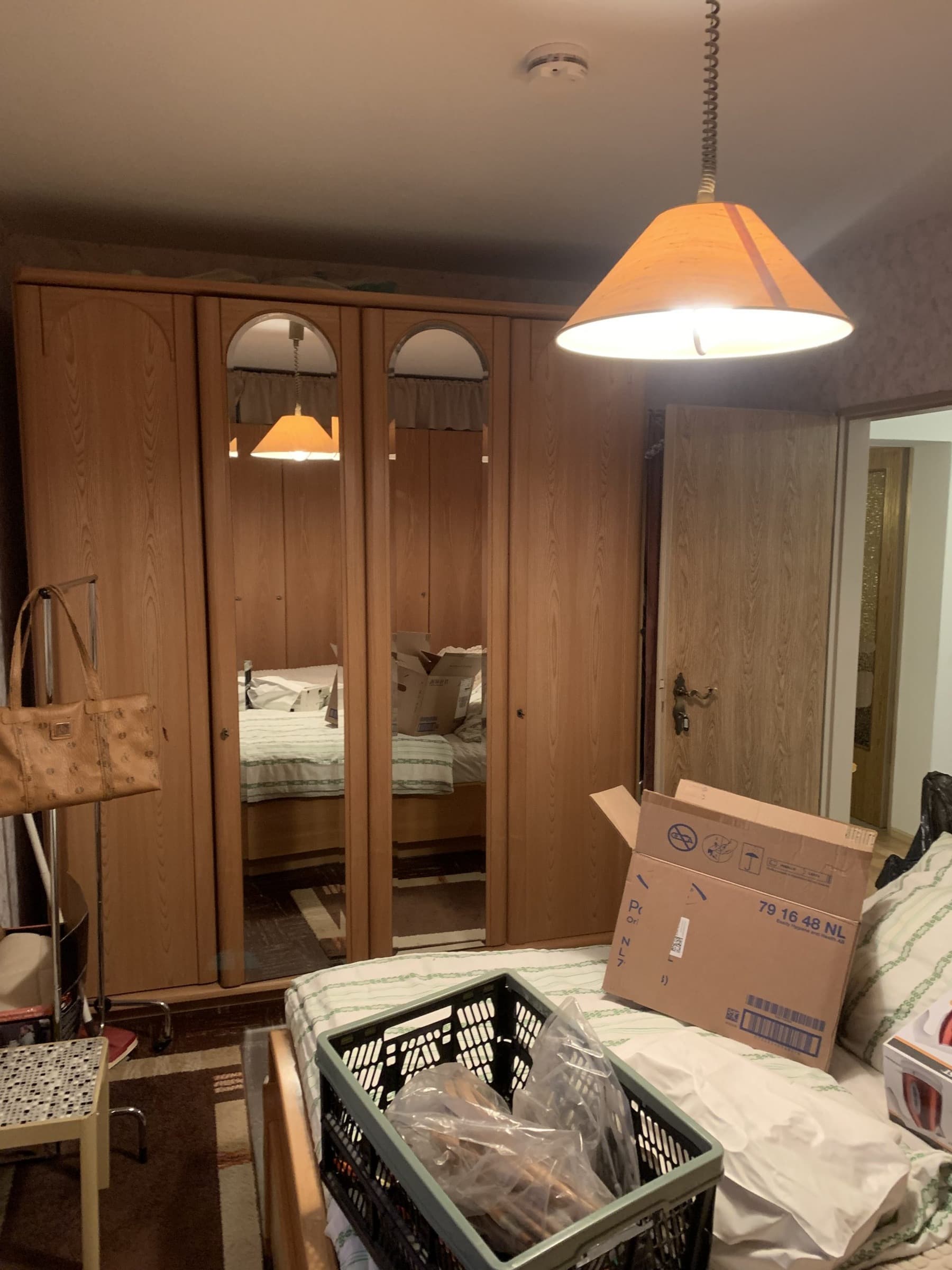 Schlafzimmer vor der Räumung mit Kleiderschrank und Kartons