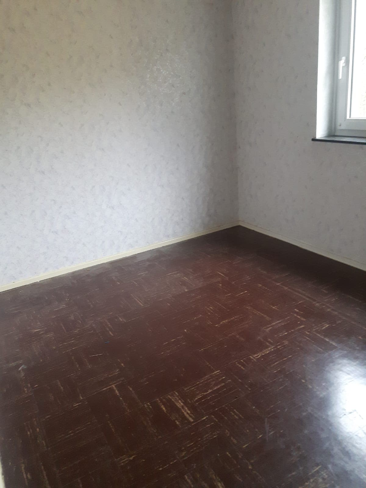 Zimmer nach der Räumung, leer mit Parkettboden