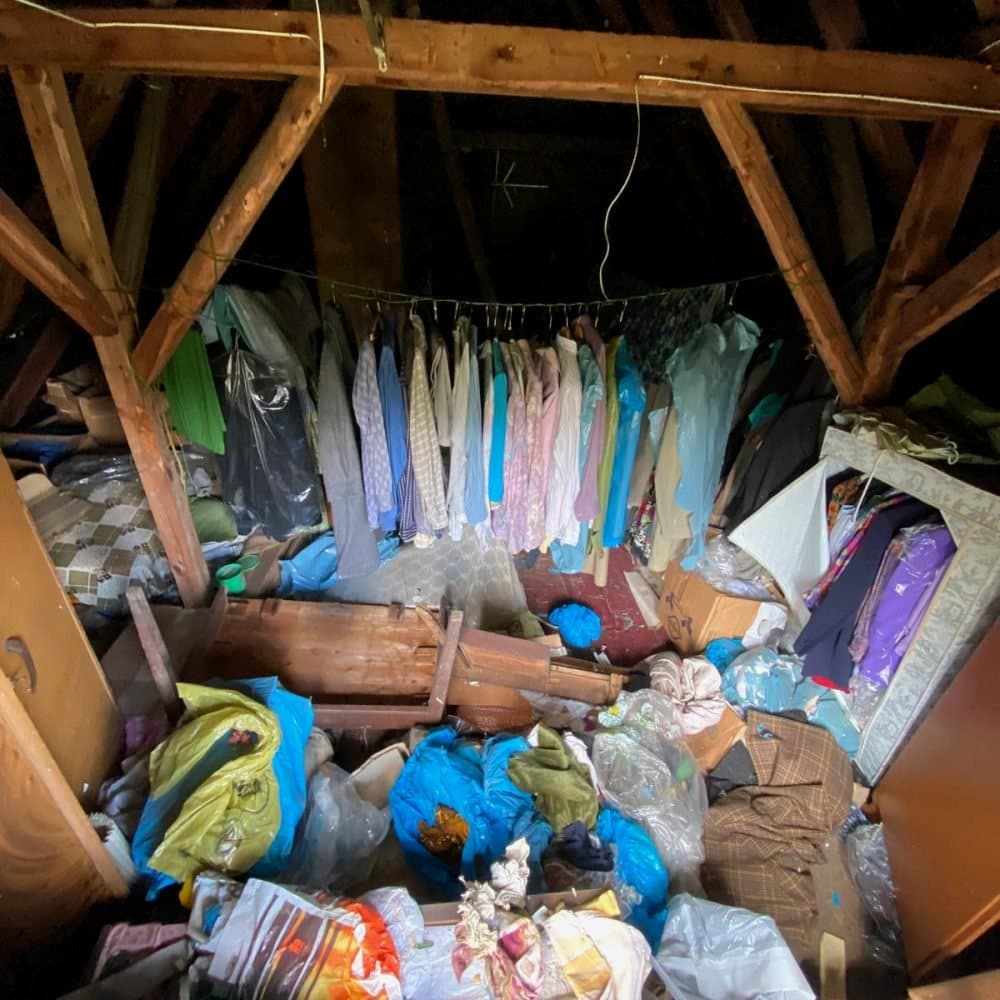 Dachboden mit Kleidung, Säcken und Möbeln