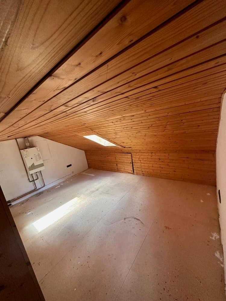 Leerer Dachraum mit Holzdecke und Dachfenster